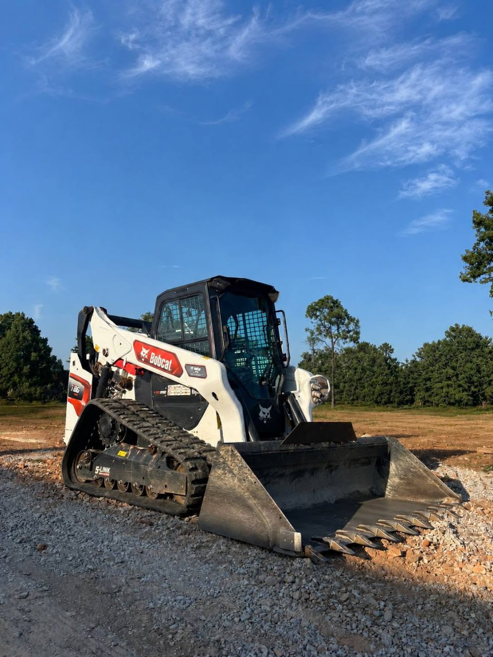Bobcat track loader with bucket on a gravel construction site